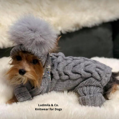 Small dog wearing a knitted merino wool jumpsuit with matching pom-pom hat, ideal for Yorkies and Chihuahuas in winter.